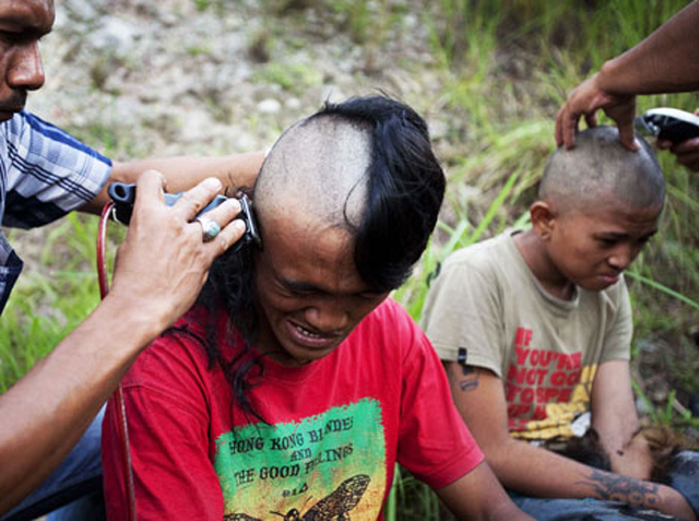 Police shave the hair of detained Indonesian punks at a police school in Aceh province